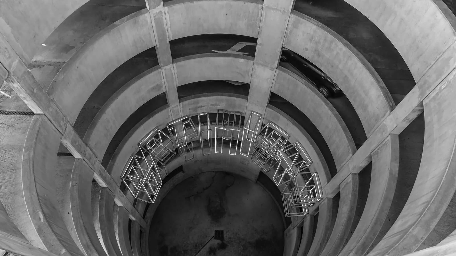 Looking down through the open core of a spiral concrete parking garage