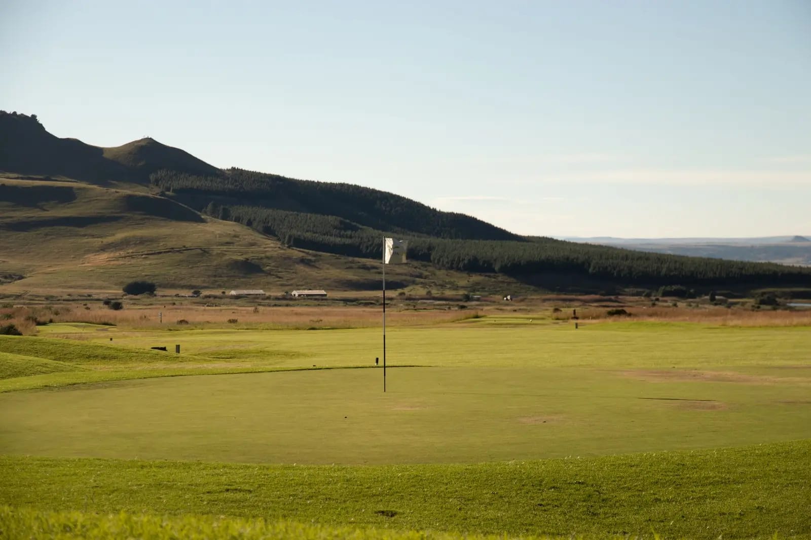 Peaceful golf course landscape with mountains and lush green in the background