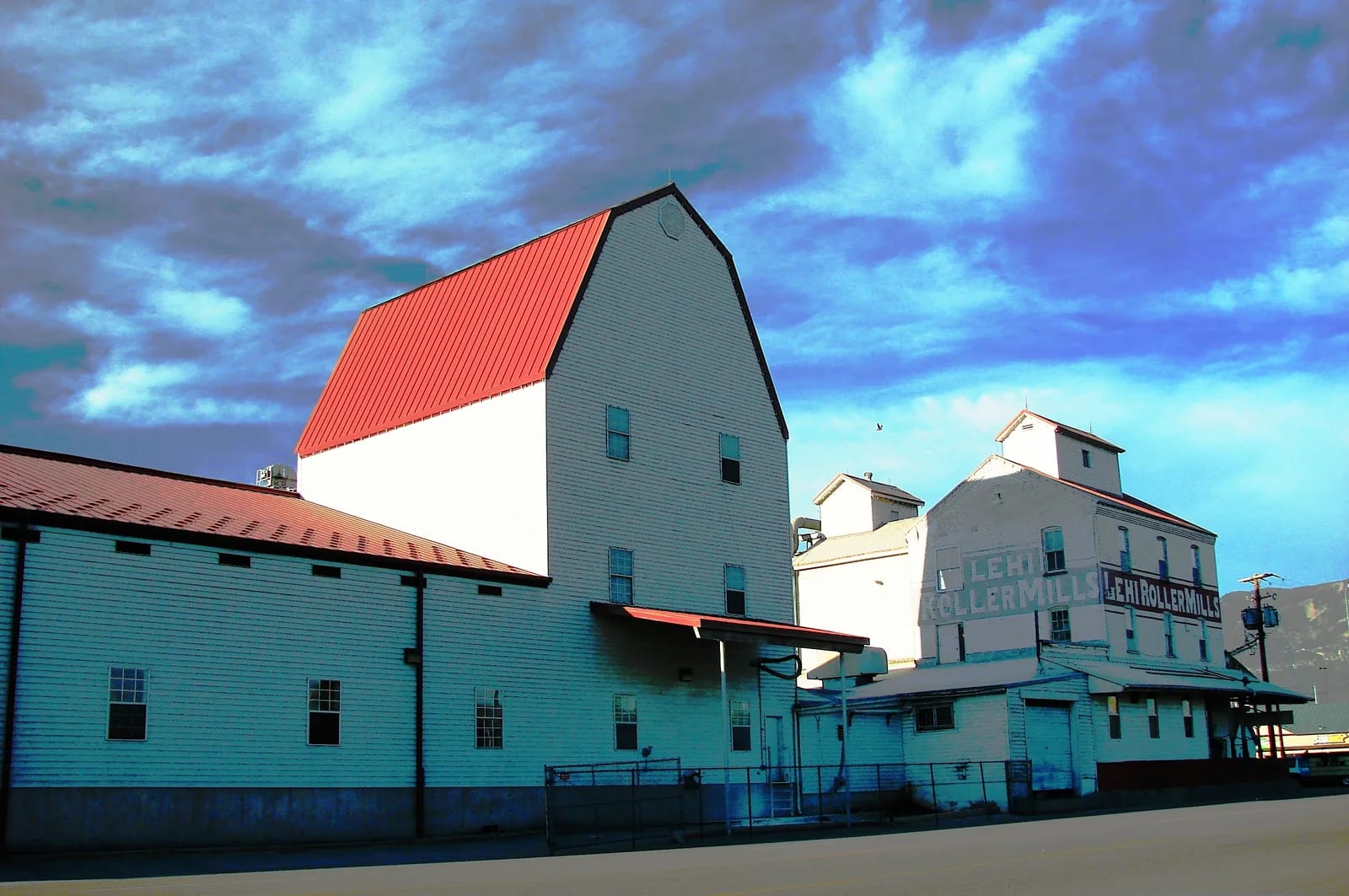 The Lehi Roller Mills buildings under a dark sky, the mill name painted across the tall block at right