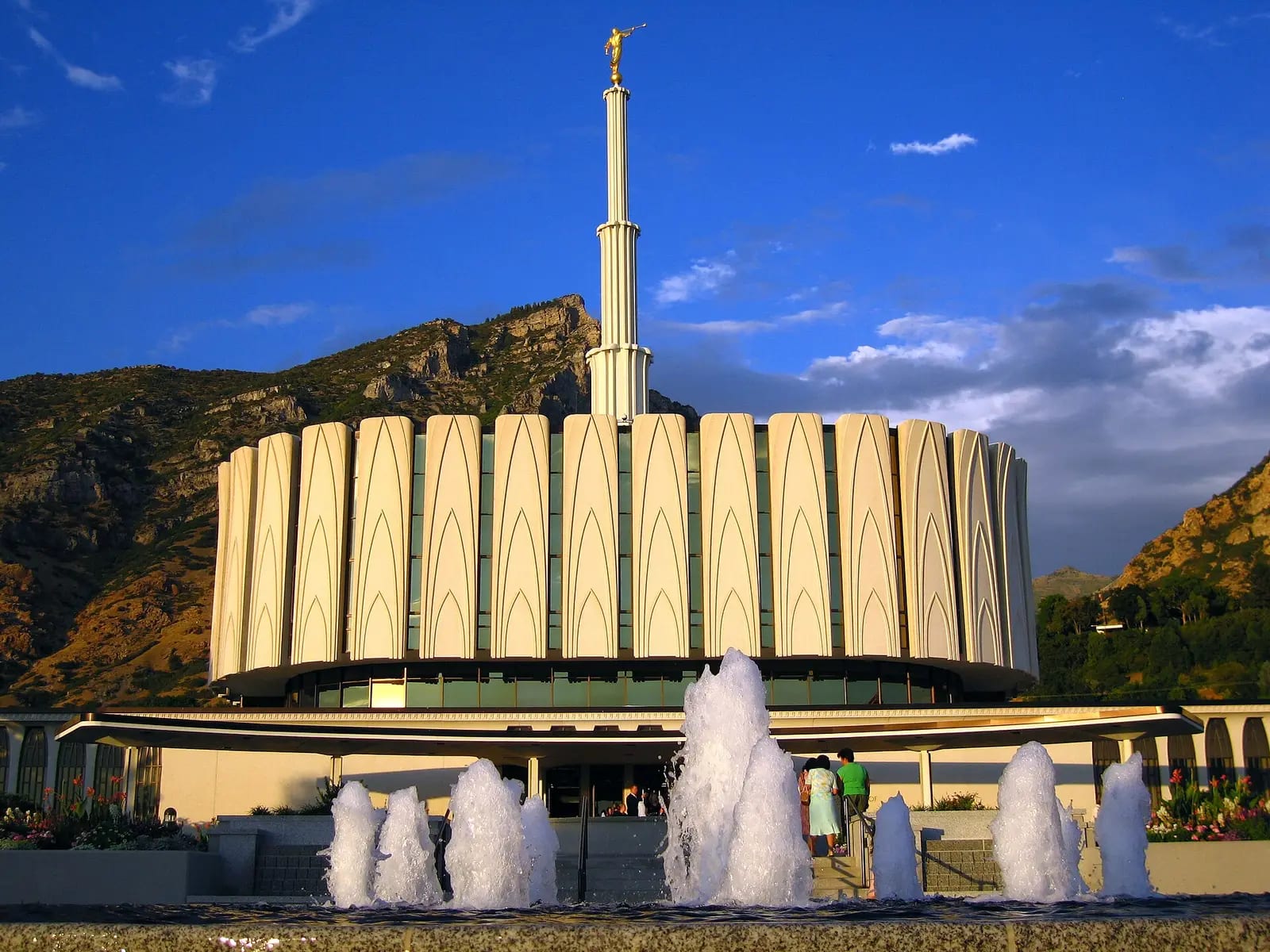 The original Provo Utah Temple, its fluted circular base and slender central spire rising behind rows of fountains