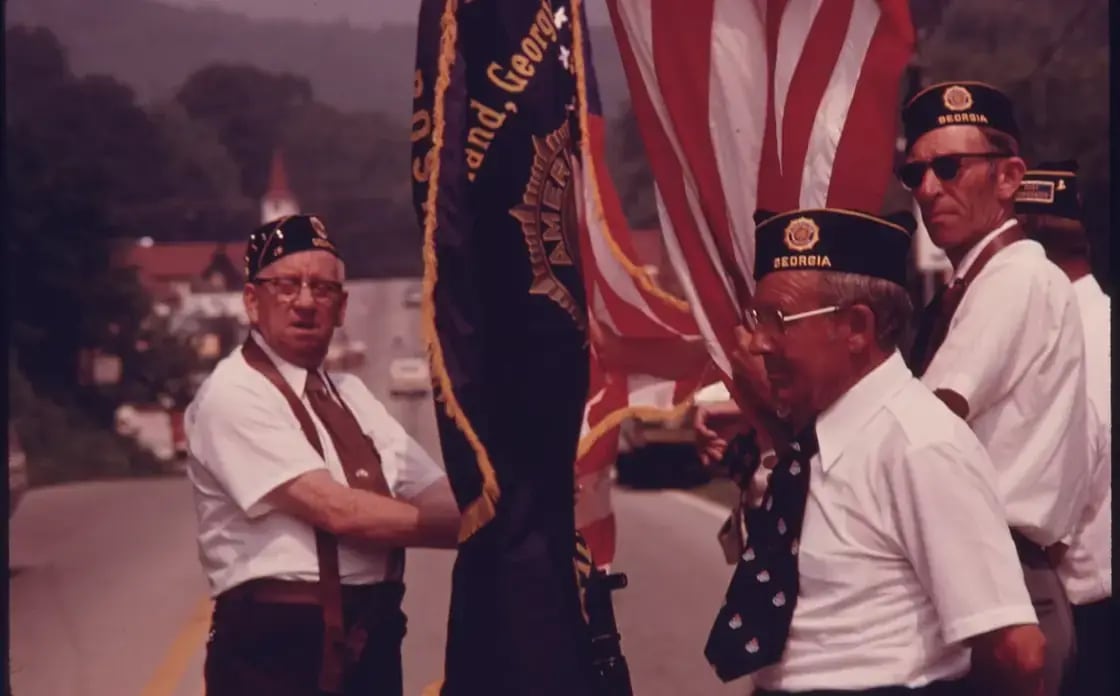 A Pioneer Day parade with wagons and flags in a Utah County town