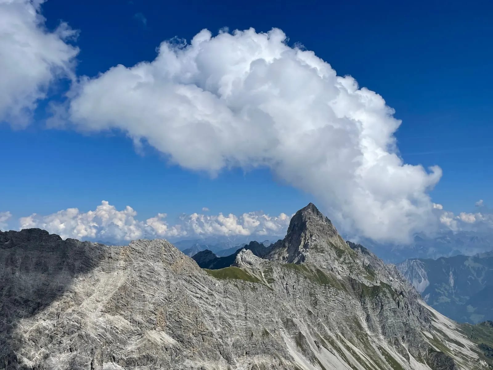 A steep ridge rising toward a rocky mountain summit