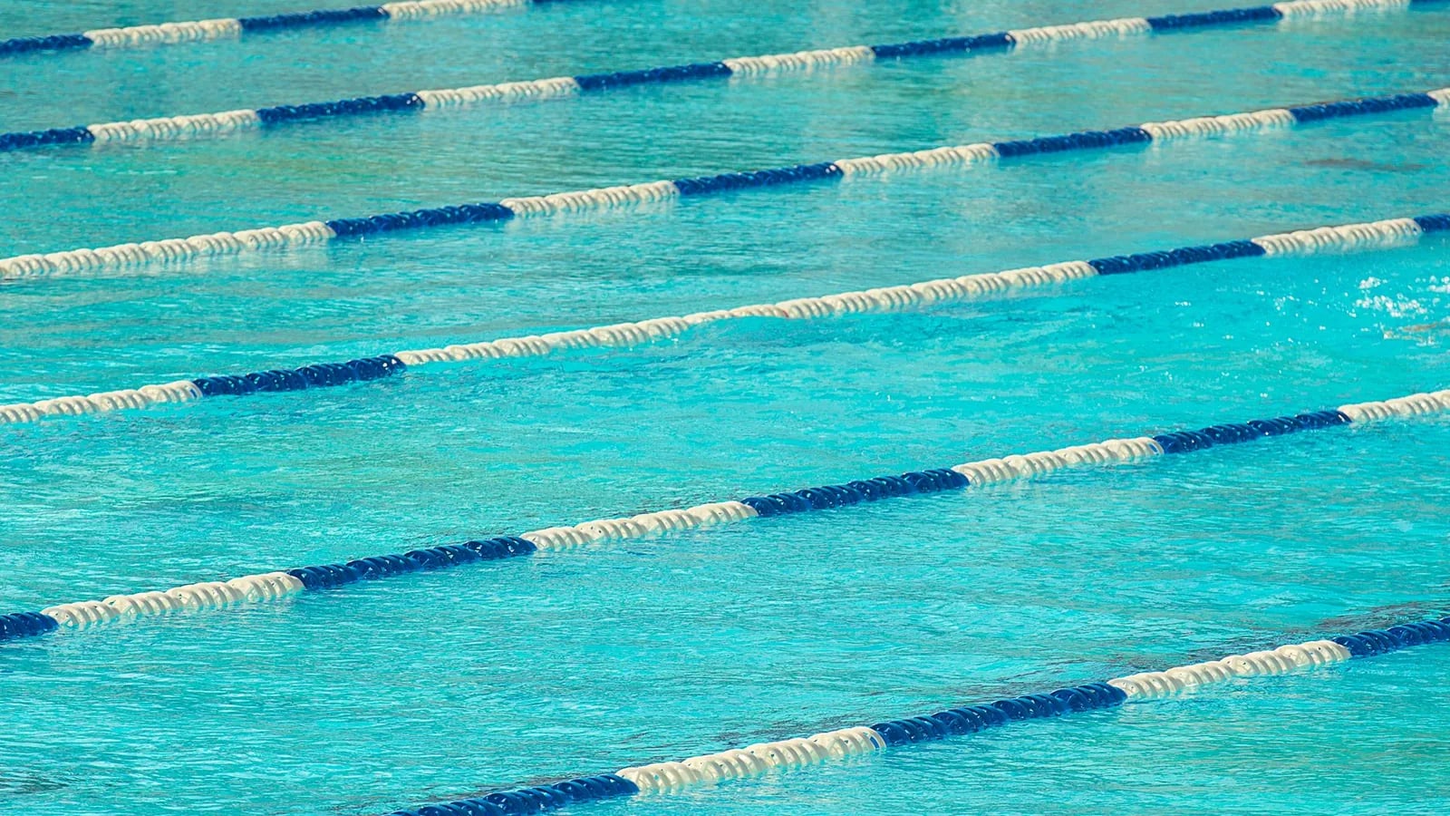 Floating lane dividers stretching across the calm water of a lap swimming pool