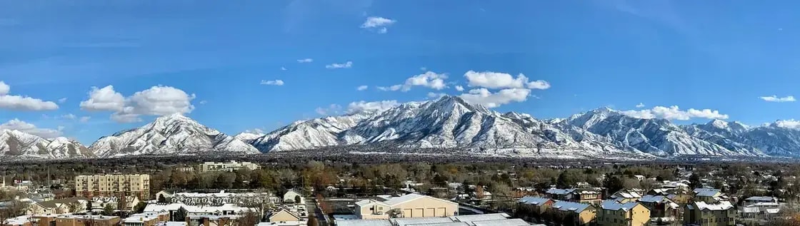 A valley town spread out below a snow-covered mountain range