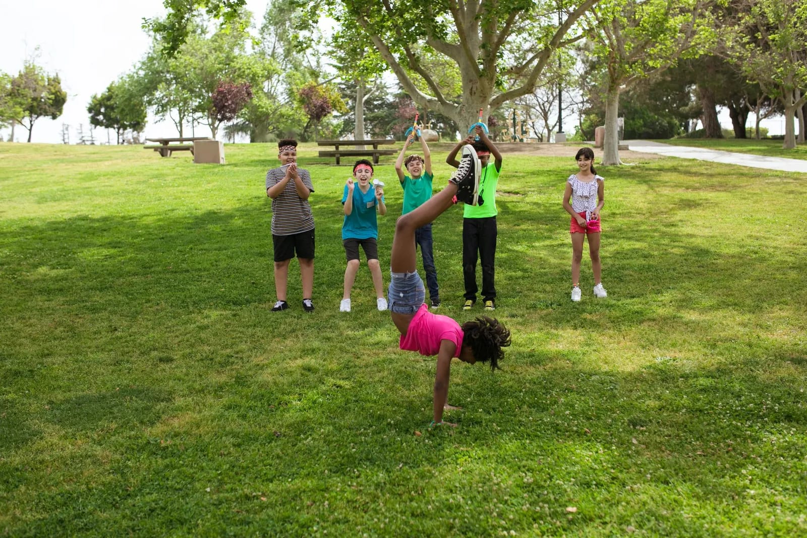 Children playing on a grass field at an outdoor summer camp session