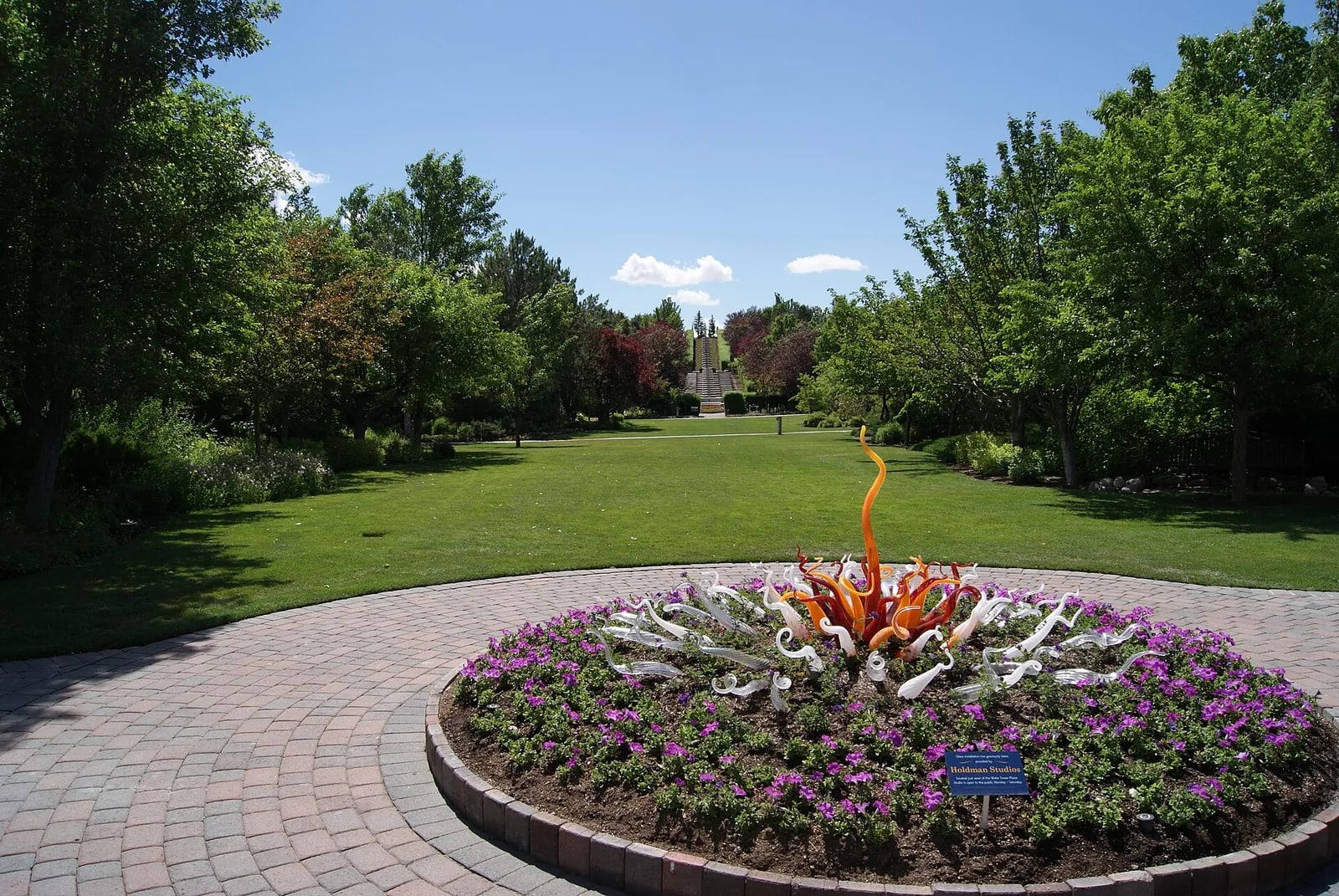 A circular flower bed and glass sculpture on a garden lawn at Thanksgiving Point in Lehi