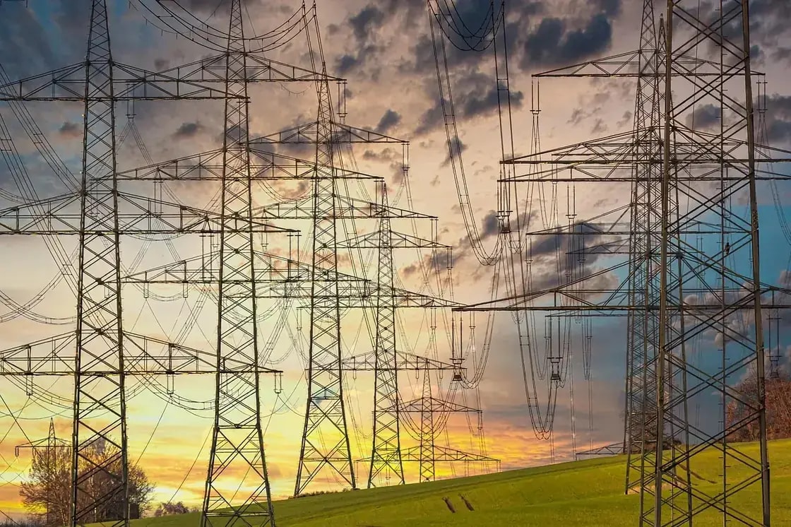 Electricity transmission towers and power lines at sunset