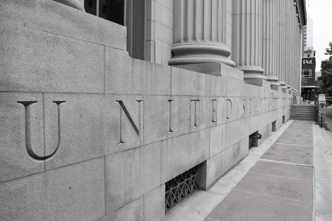 The carved stone facade of the Frank E. Moss Federal Courthouse in Salt Lake City, with the words UNITED STATES cut into the wall