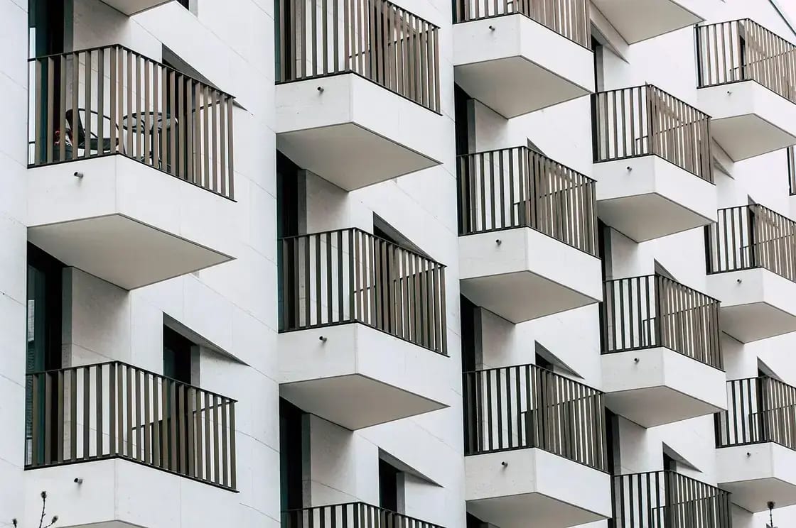 Balconies stacked in an offset pattern across the facade of a modern apartment building