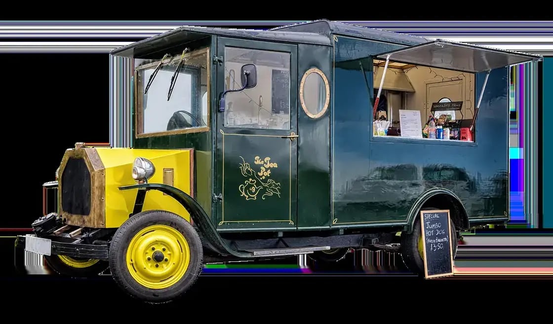 A vintage delivery truck converted into a food truck with its serving window open