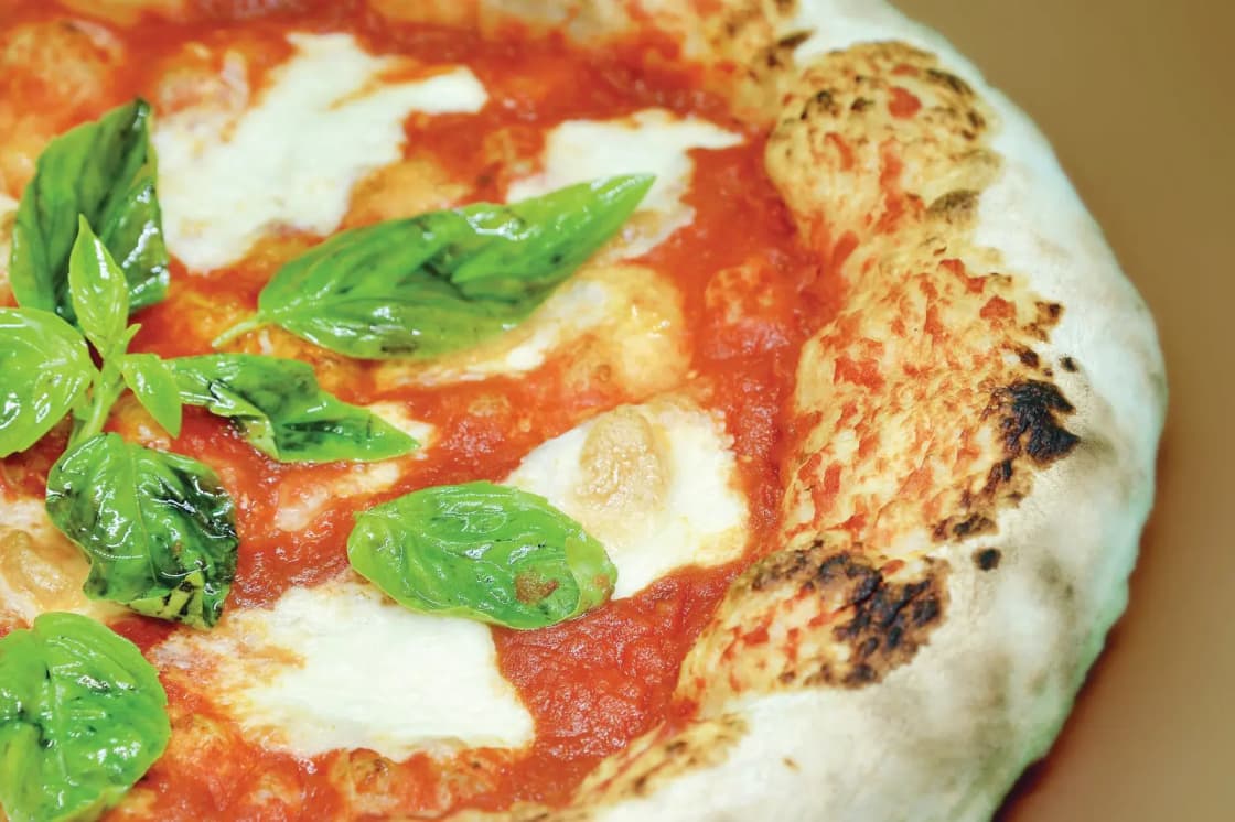 A freshly baked pizza with mozzarella and basil, straight from the oven