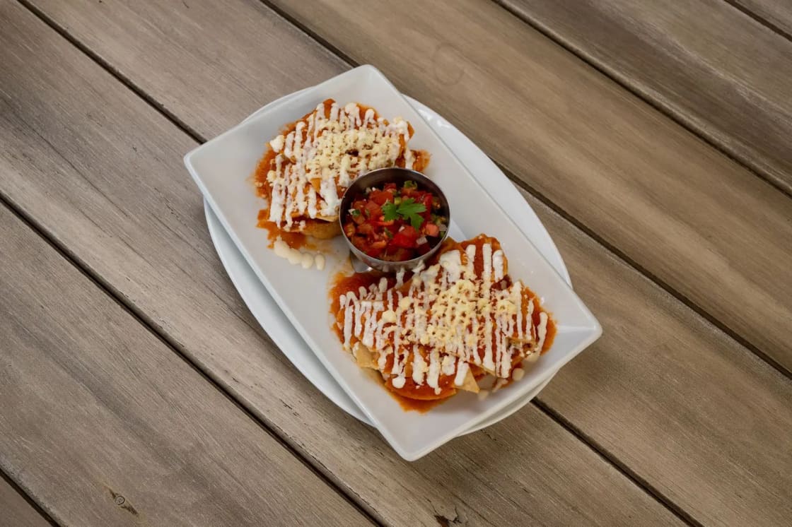 Enchiladas under melted cheese and salsa on a plate
