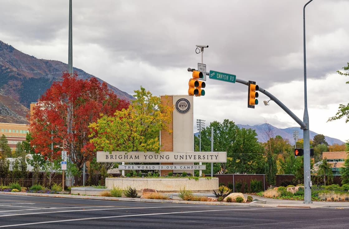 The Brigham Young University entrance sign on Canyon Road in Provo, framed by fall color