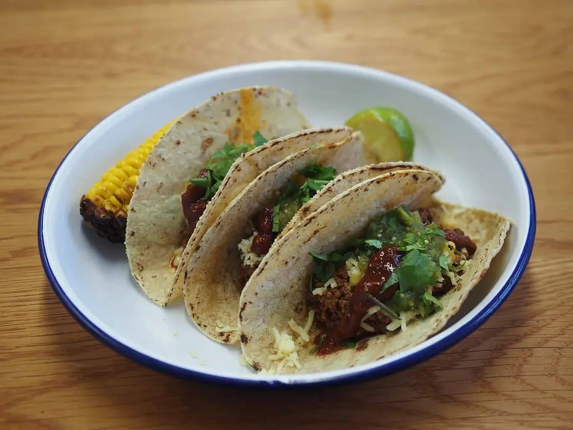 Three street tacos served on a plate