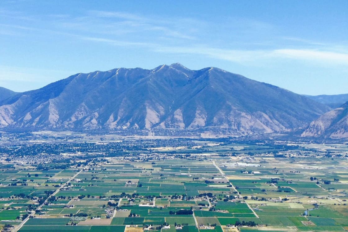 Spanish Fork Peak rising above the farm fields and towns of south Utah County on a clear day.