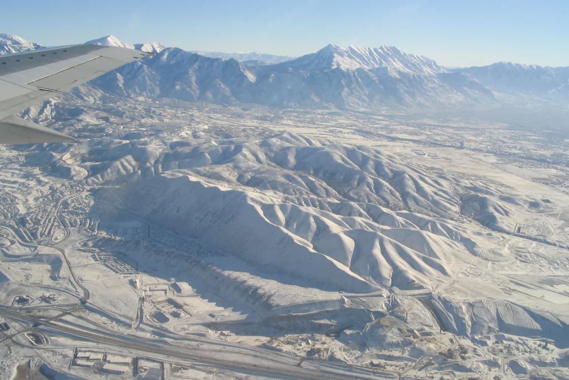 Aerial winter view from a plane of the snow-covered Traverse Mountains and neighborhoods at the north end of Lehi, Utah.
