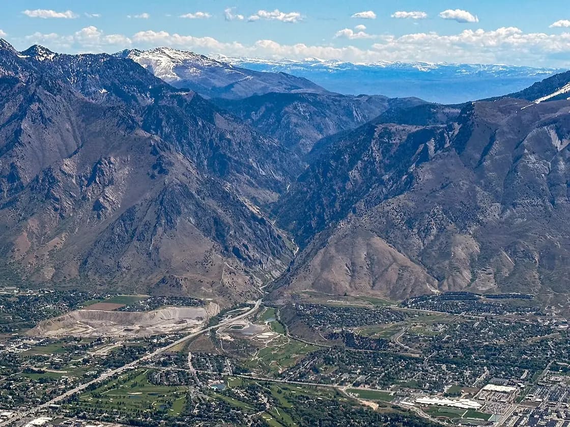 An aerial view east into the mouth of Provo Canyon, with the Utah Valley floor below and the Wasatch Range beyond