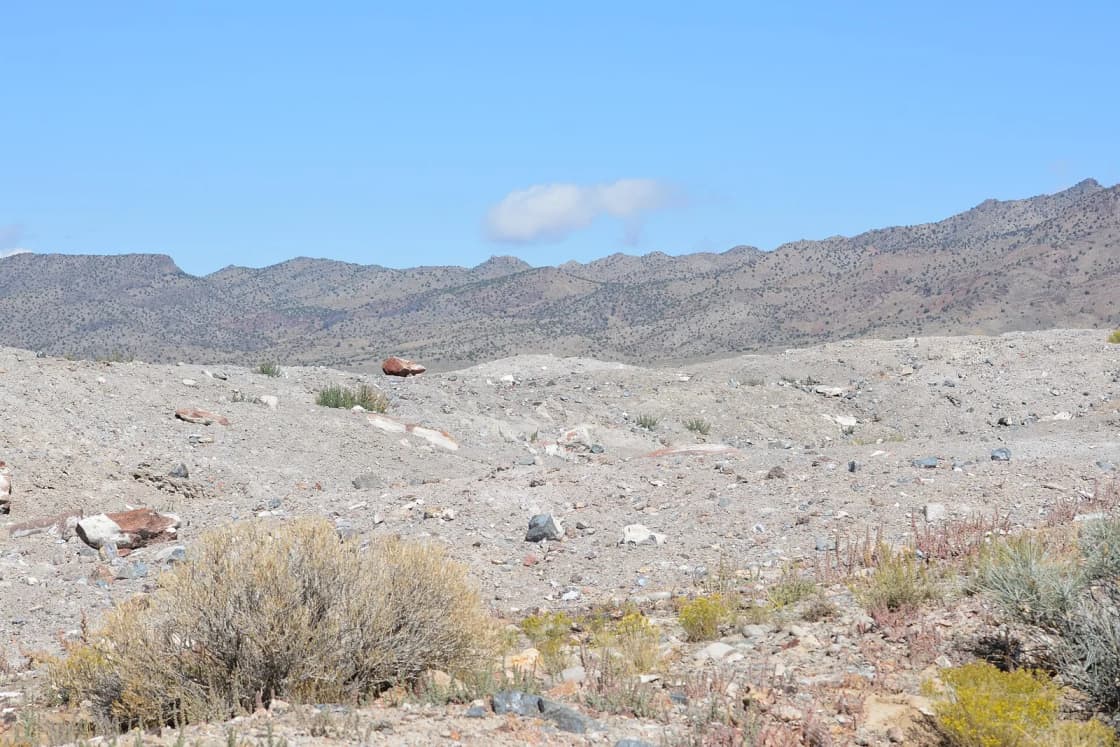 Dug-over gravel and sagebrush at the Dugway Geode Beds below dry desert mountains in western Utah.