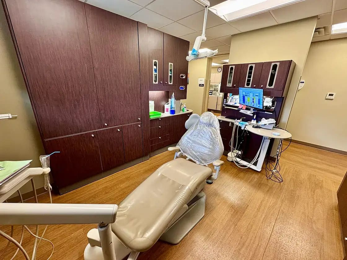 A clean, modern dental operatory with an exam chair and overhead light