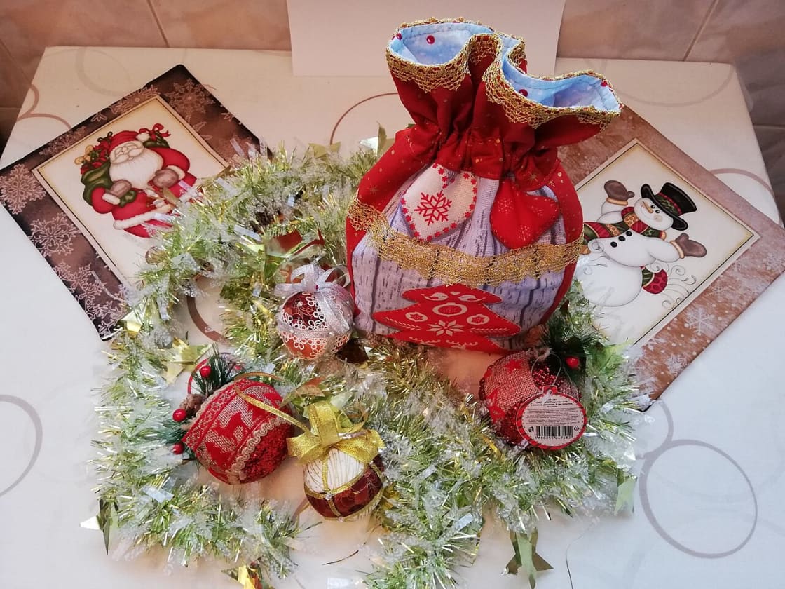 Decorated gift bags and Christmas ornaments arranged on a table