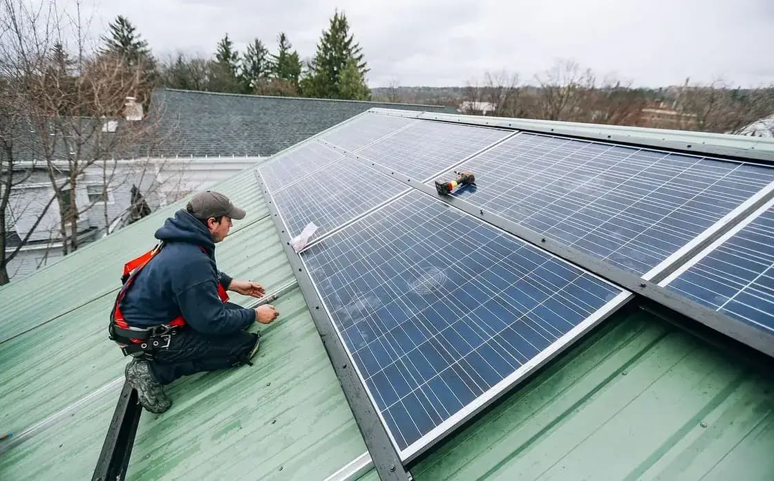 Technicians installing solar panels on a rooftop
