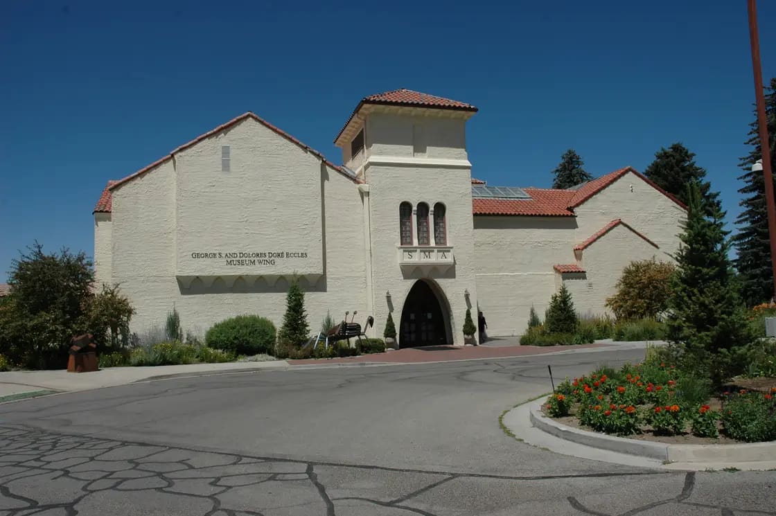 The Springville Museum of Art, a Spanish Colonial Revival building with a tiled roof and arched windows, behind lawn and trees