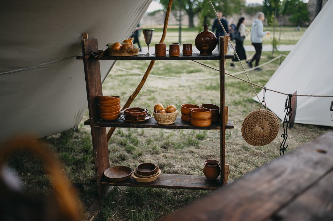 Handmade ceramic bowls and mugs arranged on a wooden table at an indoor craft market stall