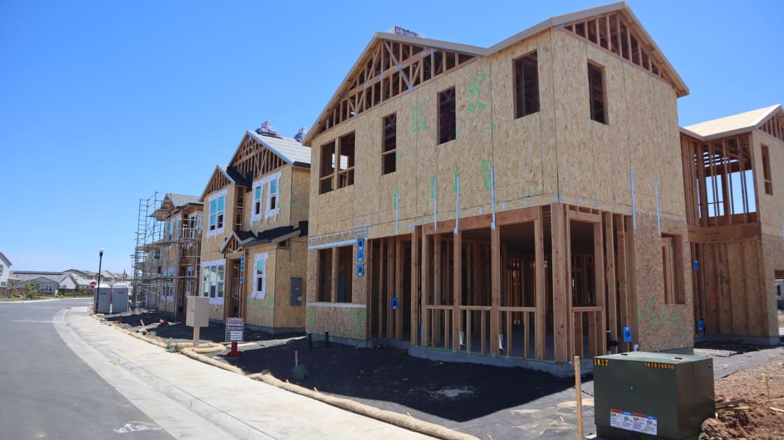 New two-story houses under construction along a freshly paved street