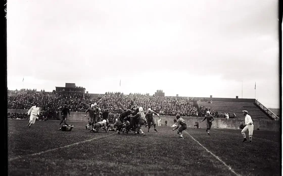 A packed college football stadium under the lights on game day