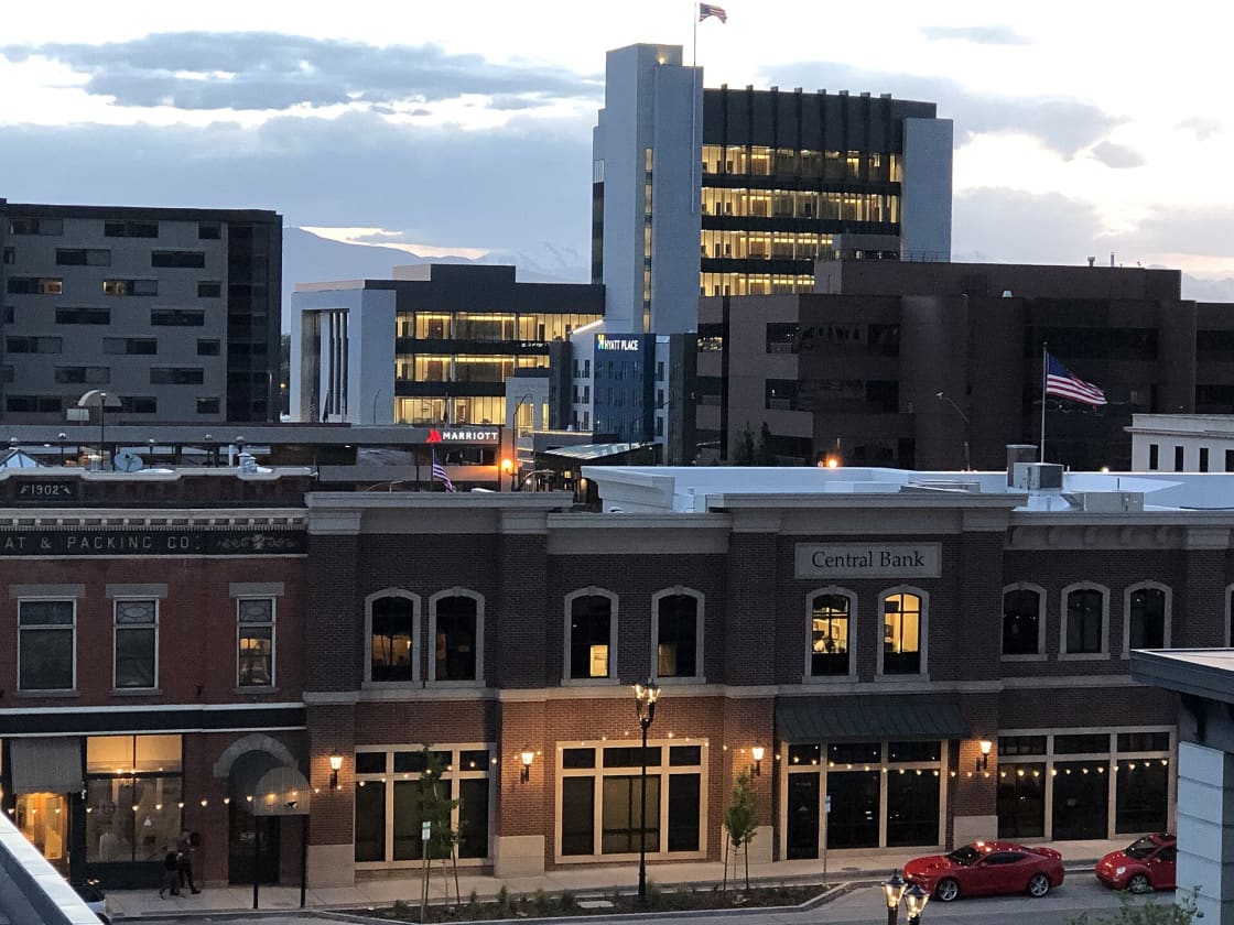 Downtown Provo at dusk, with Marriott and Hyatt Place hotel signs lit above historic brick storefronts