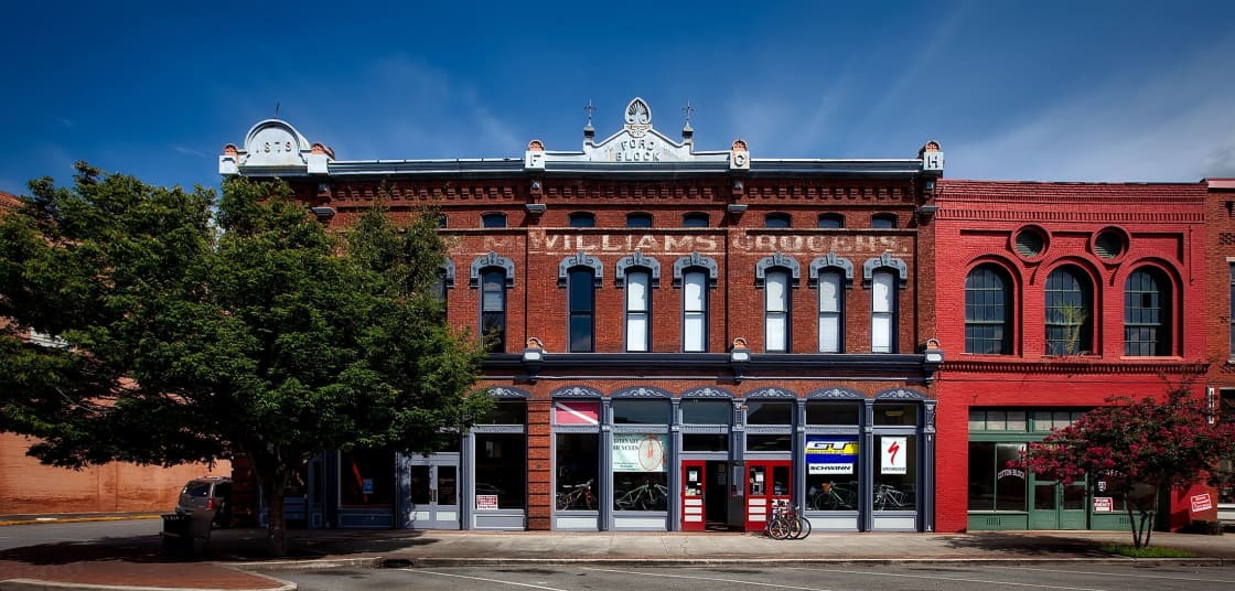 A row of ornate red brick commercial buildings on a historic downtown street