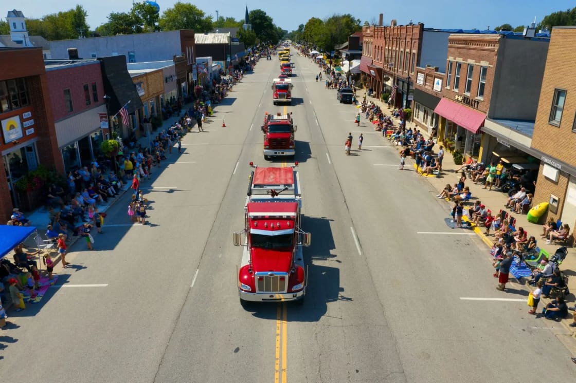 An aerial view of a parade filling a small-town main street