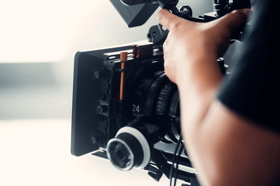 A person operating a professional video camera indoors