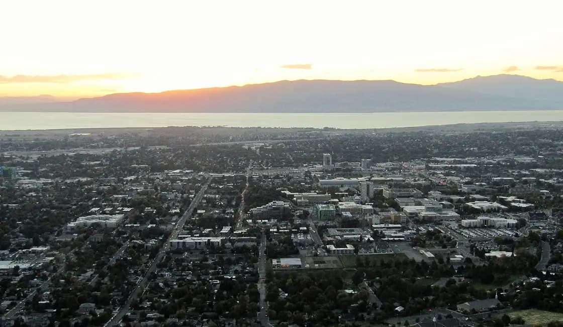 The Provo street grid at sunset seen from the mountainside east of the city, with Utah Lake and the far side of the valley beyond