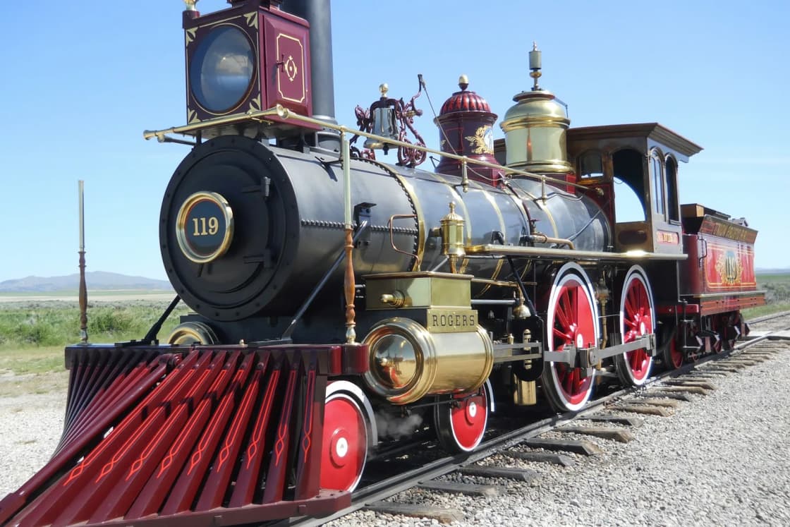 The replica steam locomotive No. 119 in red, black and brass on the tracks at Golden Spike National Historical Park