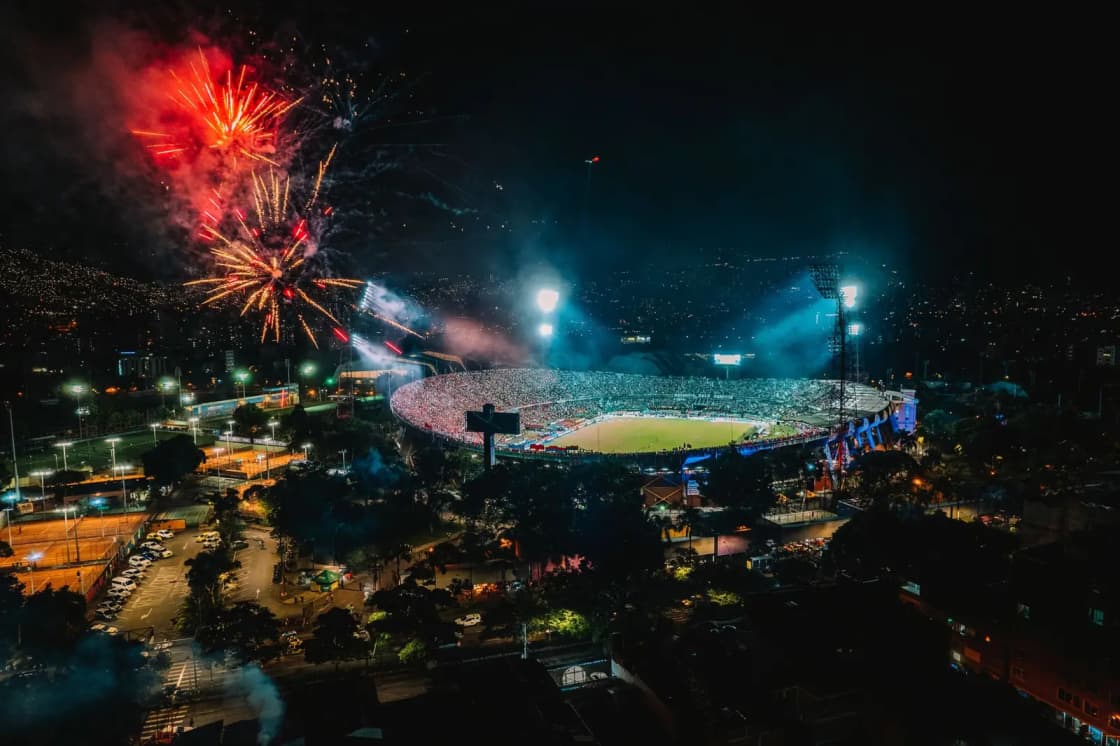 Fireworks bursting above a packed stadium at night