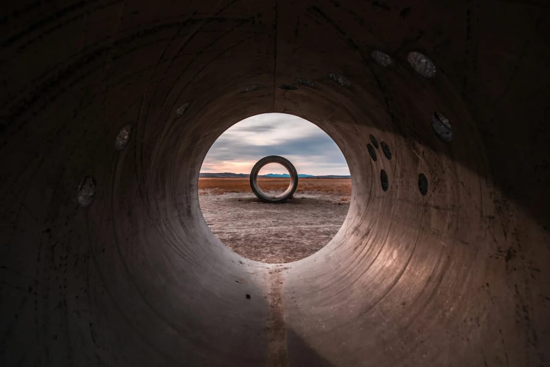 Looking out through one of the concrete Sun Tunnels in the Great Basin desert, a second tunnel framed in the round opening