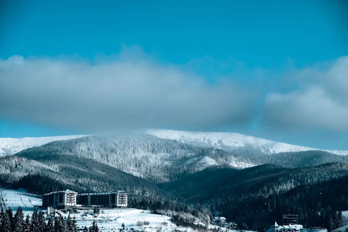 A mountain resort at the foot of a snow-covered forested slope