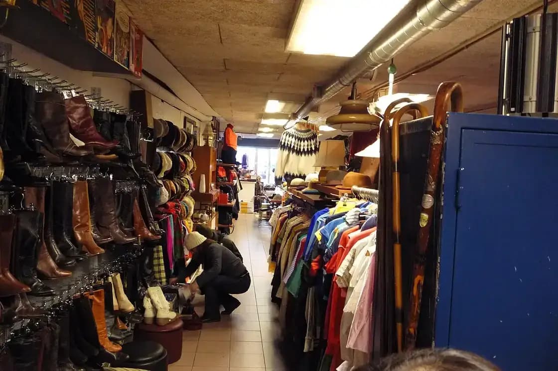 Shoppers digging through racks of vintage and secondhand clothing