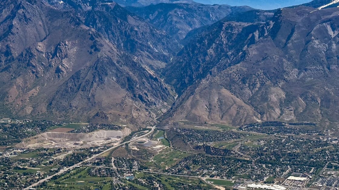 An aerial view of the Utah Valley floor, its street grid running out to the mouth of Provo Canyon between steep mountains