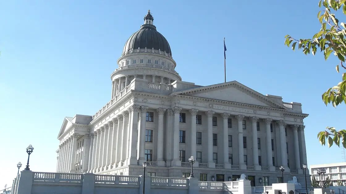 The dome and columned facade of the Utah State Capitol in Salt Lake City under a blue sky