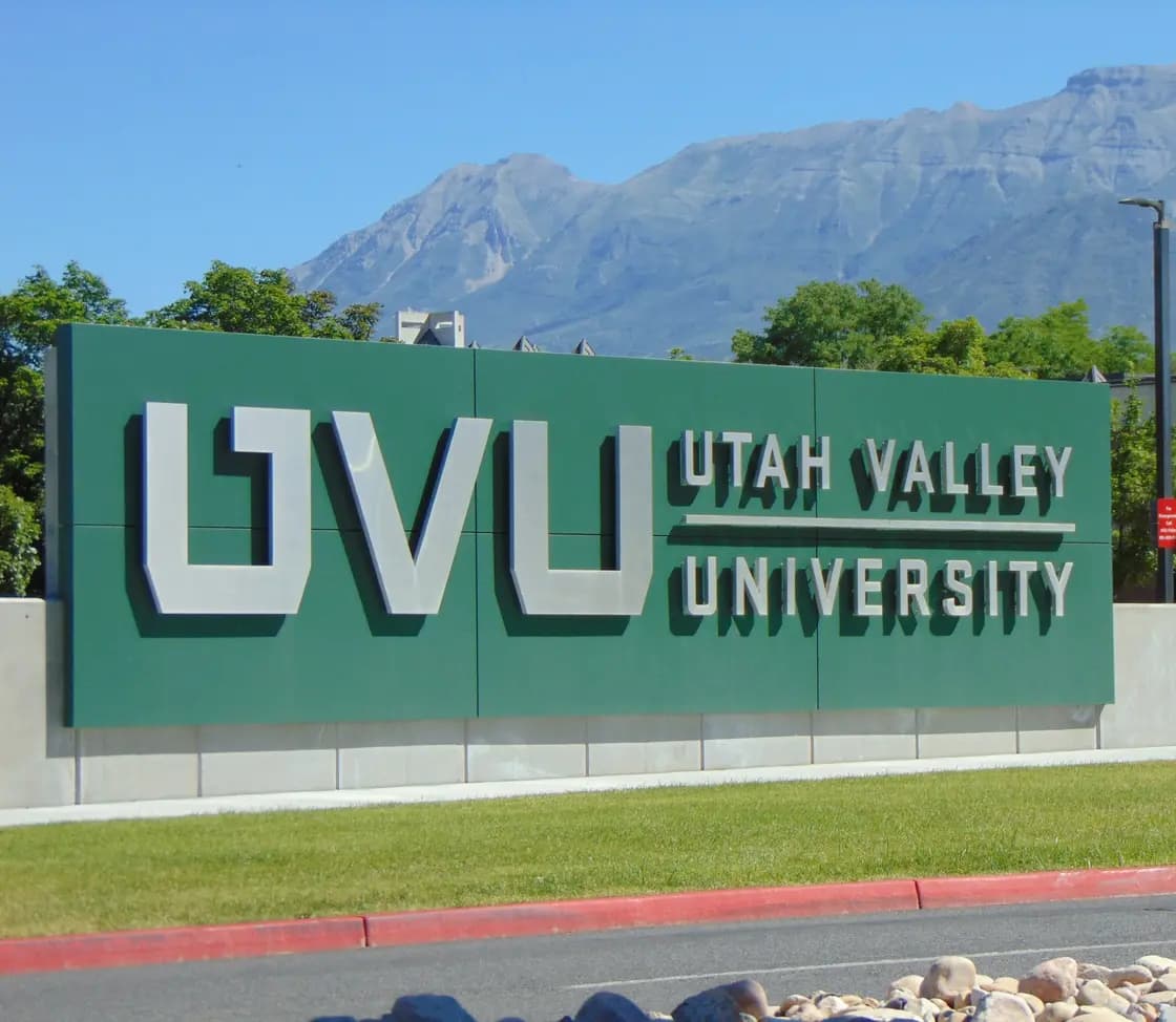 The Utah Valley University monument sign on the main campus in Orem, Utah, with Mount Timpanogos rising behind it