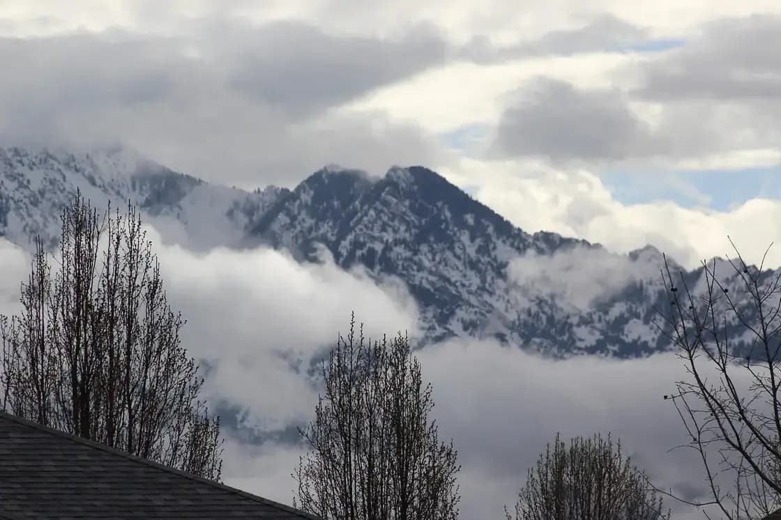 Snow-covered mountain peaks rising above low cloud