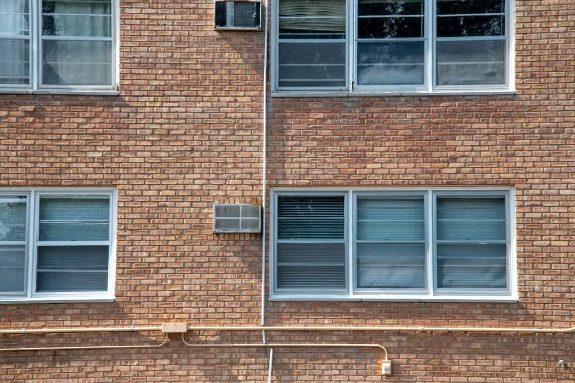 A brick apartment building facade with rows of windows