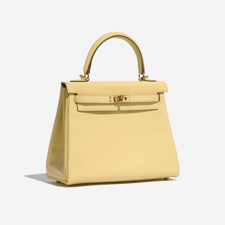 A Kelly 25 in Swift, Jaune Poussin: pale yellow that reads as luminous rather than flat, the signature of dye absorbed into a smooth skin.