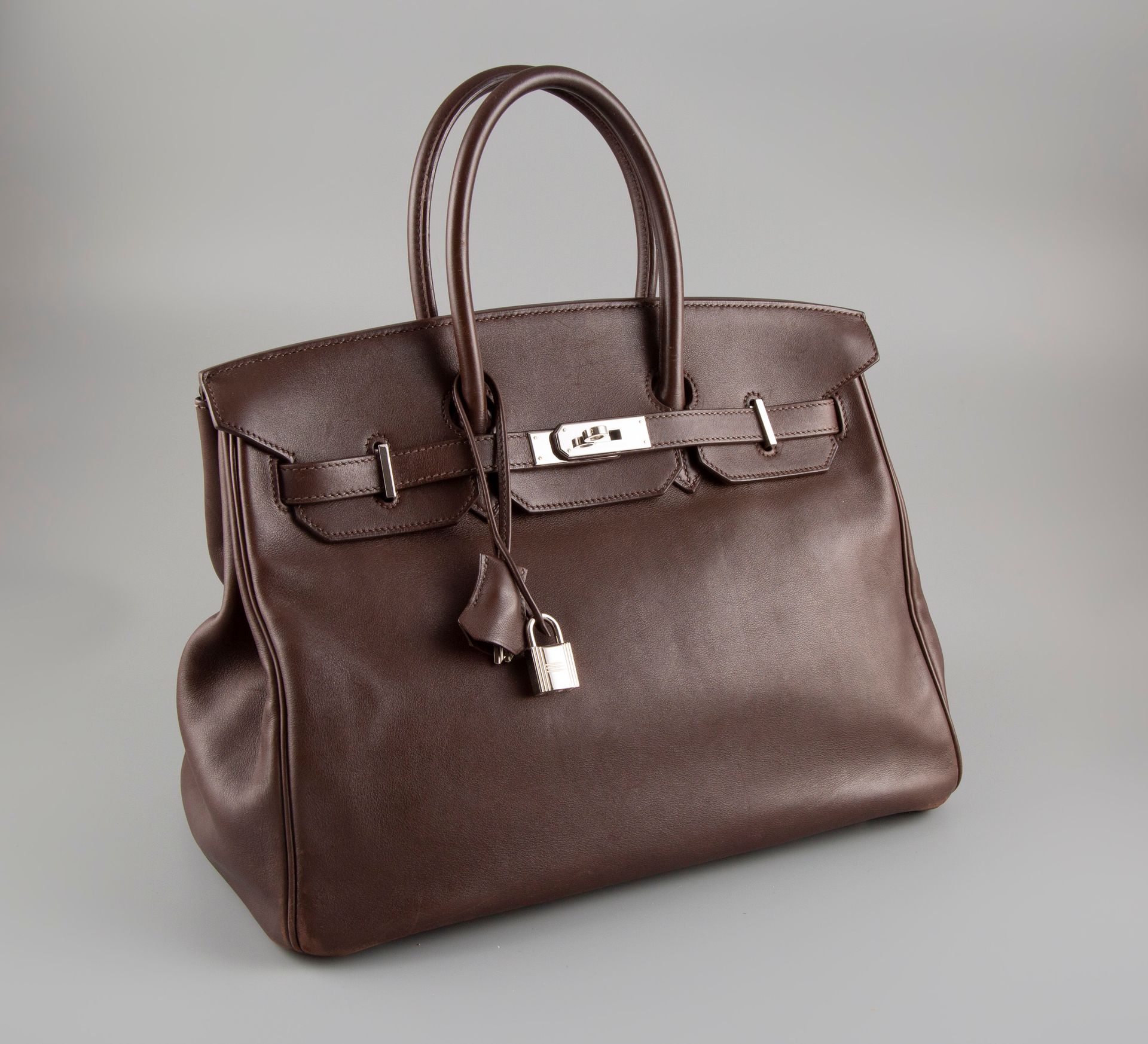 Birkin 35 in Swift, Acajou Foncé, three-quarter view: the continuous sheen and soft fold lines that identify a well-used Swift bag.