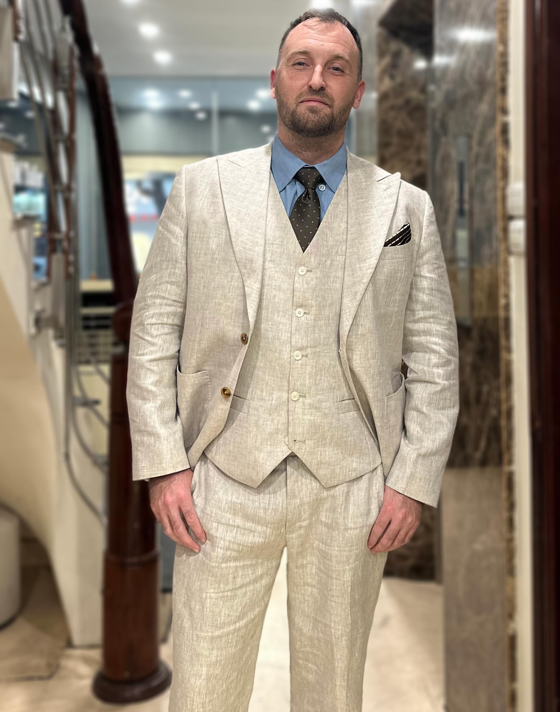 A three-piece beige linen suit designed by Unlim Tailor.