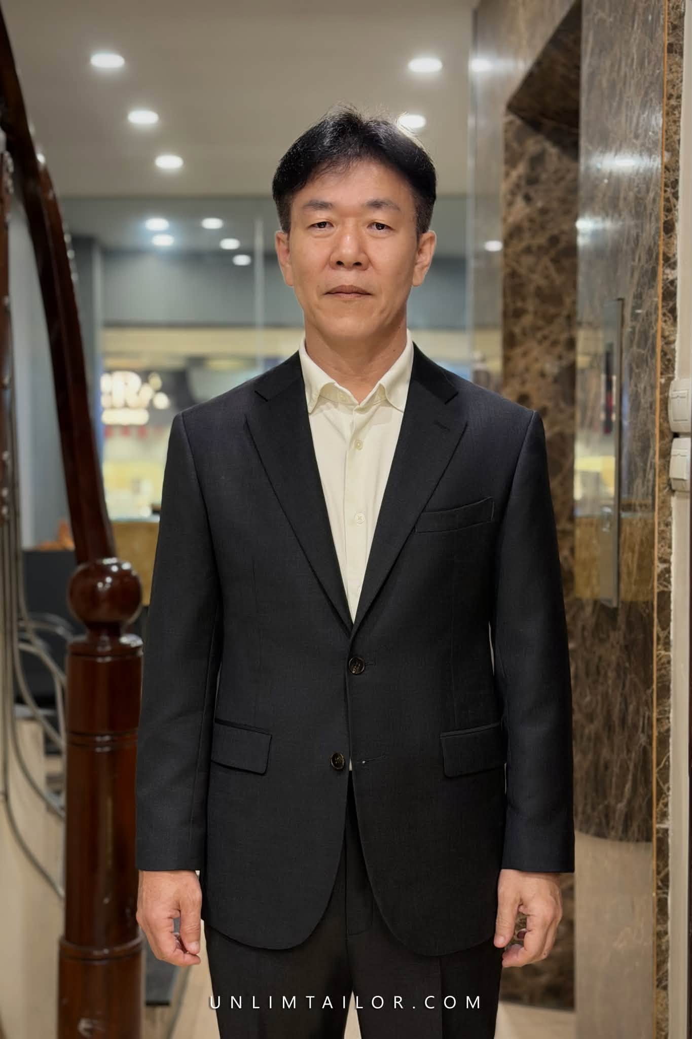 A black, two-piece, two-button suit tailored by Unlimtailor in Hanoi