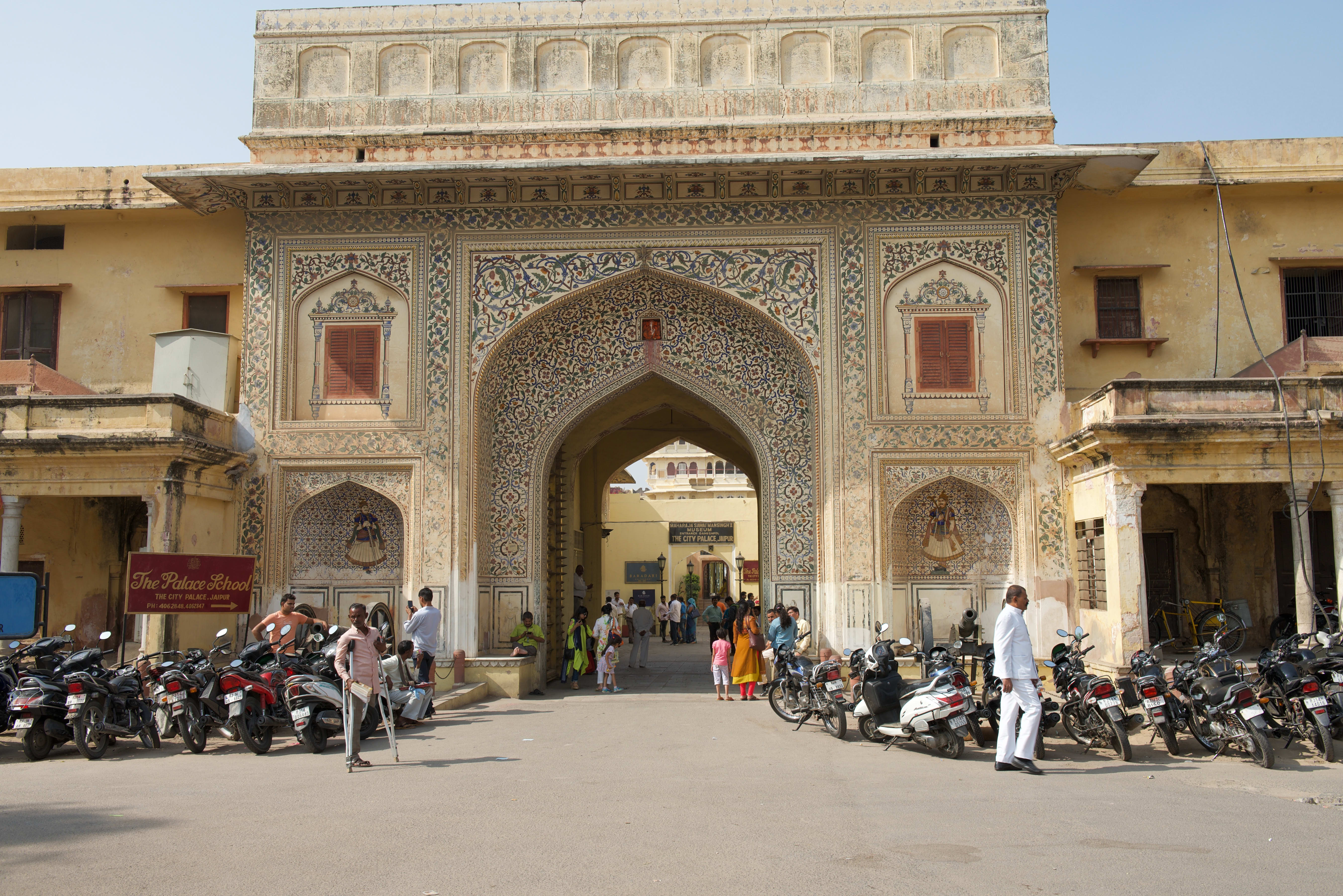 People passing near historic architectural structures in Jaipur; individual gate identification unconfirmed.