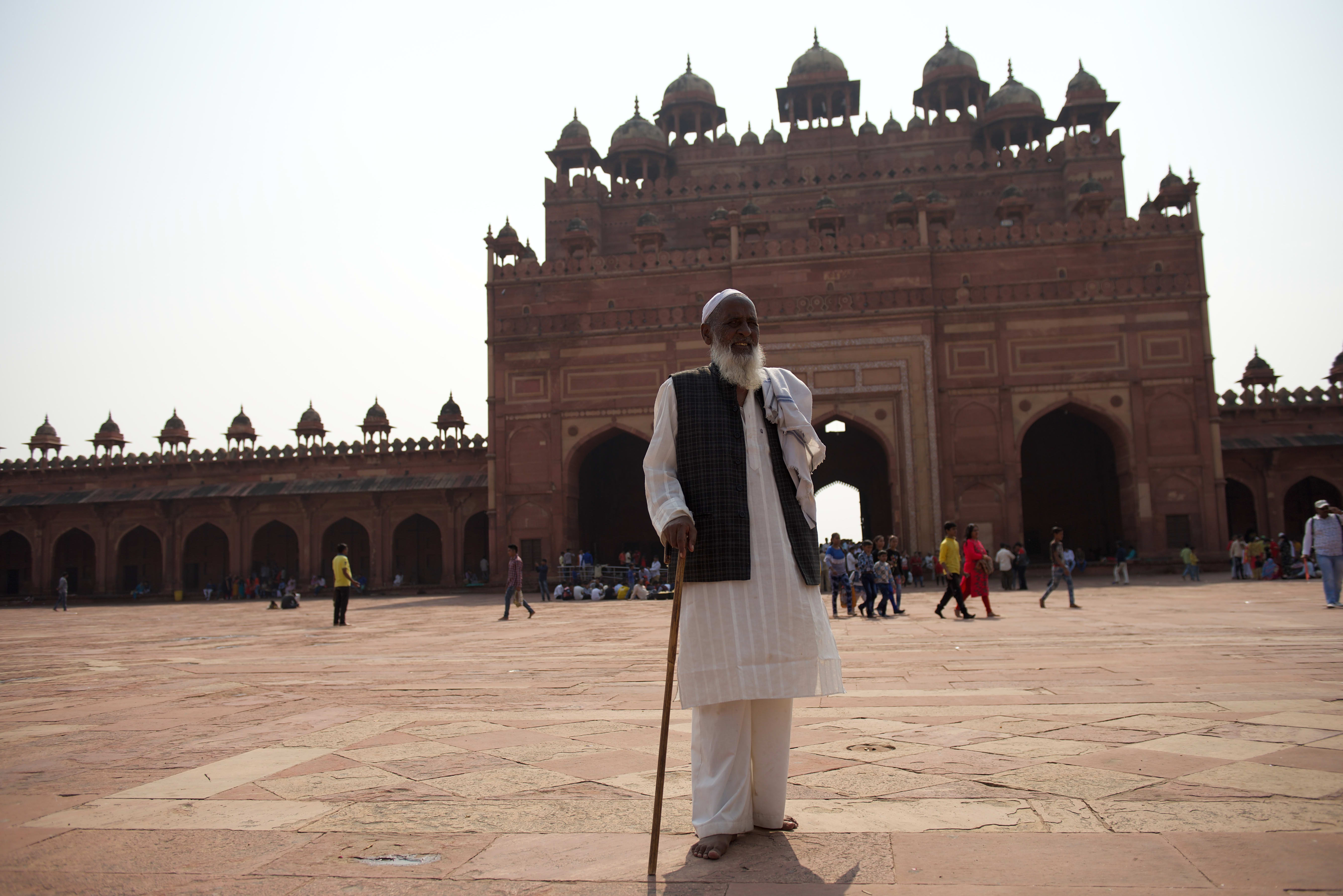 A person at a monumental red sandstone entrance at Fatehpur Sikri.